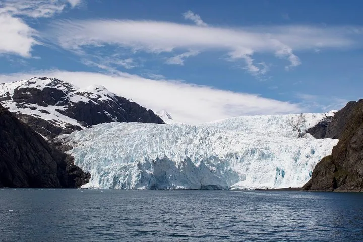 A stunning wide view of a large glacier nestled between mountains.